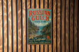 A vintage-style metal sign for Russian Gulch State Park, featuring a scenic landscape with a river, mountains, and pine trees.