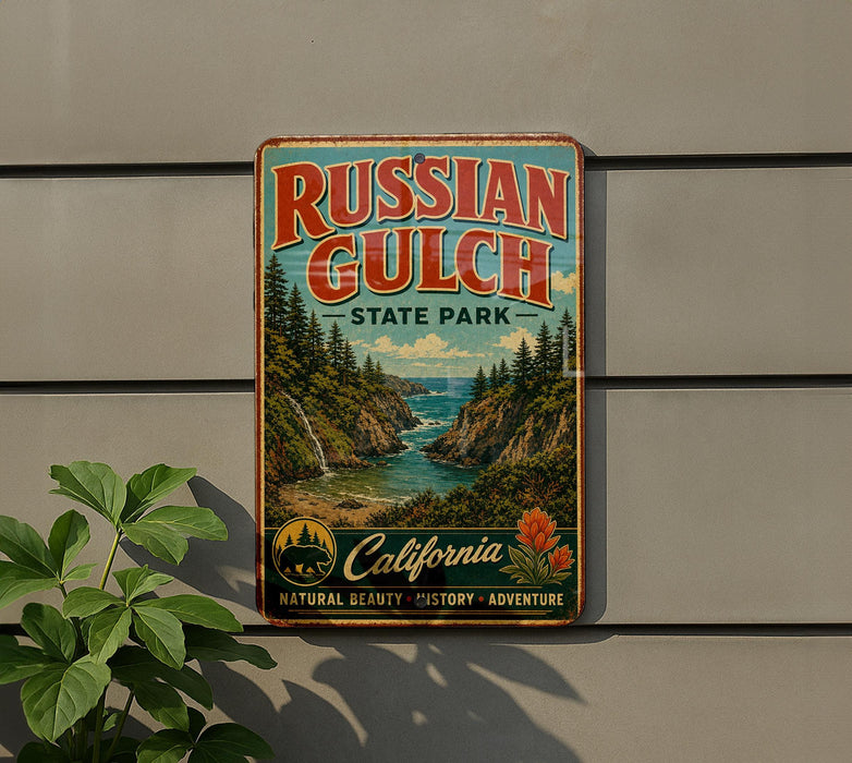 A vintage-style metal sign for Russian Gulch State Park in California, featuring a scenic landscape with a waterfall and pine trees.