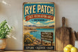 A vintage-style sign for Rye Patch State Recreation Area in Nevada, featuring a scenic landscape with mountains, water, and a sign indicating various recreational activities.