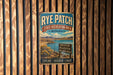 A vintage-style metal sign for Rye Patch State Recreation Area in Nevada, featuring a scenic landscape with mountains, water, and a sign that says "Adventure Relaxation Wide Open Spaces".