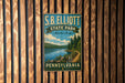 A vintage metal sign for S.B. Elliott State Park in Pennsylvania, featuring a scenic landscape with a lake and forest.