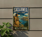 A vintage-style metal sign for Sacajawea State Park in Washington, featuring an illustration of a woman in traditional clothing standing on a cliff overlooking a river.