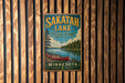 A vintage metal sign for Sakatah Lake State Park in Minnesota, featuring a canoe and a scenic landscape.