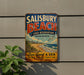 A vintage metal sign for Salisbury Beach State Reserve in Massachusetts, featuring a beach scene with a beach, ocean, and palm trees.