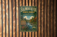A vintage-style metal sign for the Salmon River State Forest in Connecticut, featuring a scenic image of the river surrounded by trees and mountains.