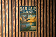 A vintage-style metal sign for Sam Dale Lake, Illinois, featuring a duck flying over a lake and a sunset in the background.