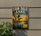 A vintage-style sign for Sam Dale Lake, featuring a duck in flight and a sunset over the lake, mounted on a wall.