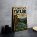 A vintage-style metal sign for Samuel P. Taylor State Park in California, featuring a scenic illustration of a river and forest.