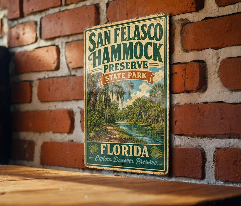 A vintage-style metal sign for San Francisco Hammock Preserve, featuring a tropical landscape with palm trees and a river, mounted on a brick wall.