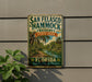 A vintage-style metal sign for San Francisco Hammock Preserve, featuring a tropical landscape with palm trees and a river.