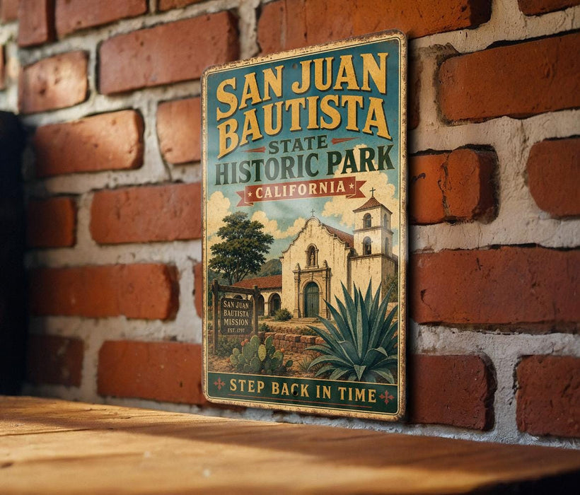 A vintage-style metal sign for San Juan Bautista State Historic Park in California, featuring an illustration of a historic building and a palm tree.