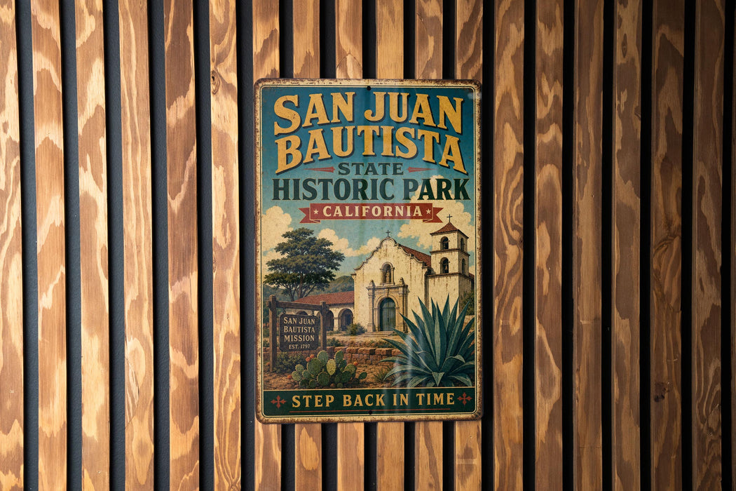 A vintage-style metal sign for San Juan Bautista State Historic Park in California, featuring an illustration of a historic building and a palm tree.