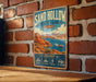 A vintage-style metal sign for Sand Hollow State Park in Utah, featuring a scenic illustration of the park's landscape and water.