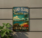 A vintage-style metal sign for the "Sand Island State Recreation Area" in Hawaii, featuring a beach scene with a palm tree, ocean, and hibiscus flowers.