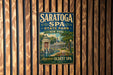 A vintage-style metal sign for Saratoga Spa, New York, with a scenic illustration of the spa and surrounding landscape.