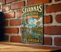 A vintage-style sign for Savannas Preserve State Park in Florida, featuring a bird and palm trees, is displayed on a brick wall.