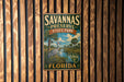 A vintage-style metal sign for Savannas Preserve State Park in Florida, featuring a bird illustration and text.