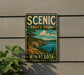 A vintage-style metal sign for Scenic State Park in Minnesota, featuring a scenic landscape with pine trees, a lake, and mountains.