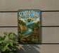 A vintage-style metal sign for Scio Trail State Park in Ohio, featuring a scenic landscape with a river and lush greenery.