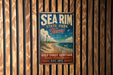 A vintage metal sign for Sea Rim State Park in Texas, featuring a lighthouse and beach scene, is displayed on a wooden wall.