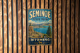 A vintage metal sign for Seminoe State Park in Wyoming, featuring a scenic landscape with mountains, water, and a pine tree.