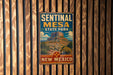 A vintage metal sign for Sentinal Mesa State Park in New Mexico, featuring a mountain landscape and the text "Sentinal Mesa State Park" and "New Mexico".