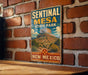 A vintage metal sign for Sentinal Mesa State Park in New Mexico, featuring a desert landscape with a prominent mountain.