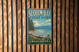 A vintage-style metal sign for Sequim Bay State Park in Washington, featuring a scenic landscape with mountains, pine trees, and a lake.