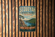 A vintage-style metal sign for Sequoyah State Park in Oklahoma, featuring a scenic landscape with a lake and mountains.