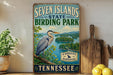 A vintage-style sign for Seven Islands State Birding Park in Tennessee, featuring a large blue heron in a natural setting.