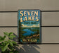 A metal sign with the text "SVEN LAKES STATE PARK" and "MICHIGAN" is displayed on a wall, with a plant to the left of the sign.