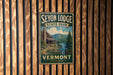 A vintage metal sign for Seyon Lodge State Park in Vermont, featuring a scenic illustration of a cabin surrounded by nature.