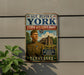 A vintage metal sign featuring a portrait of a man in military uniform, with the text "SGT. ALVIN C. YORK STATE HISTORIC PARK" and "THE STORY OF AN AMERICAN HERO" below.