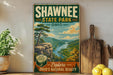 A vintage-style sign for Shawnee State Park, Ohio, featuring a scenic landscape with a river, mountains, and trees.
