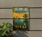 A vintage-style sign for Sheldon Lake State Park in Texas, featuring a scenic illustration of a lake, a bird, and a sunset.