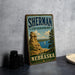 A vintage-style metal sign for Sherman State Recreation Area in Nebraska, featuring a scenic landscape with a rocky outcrop, a lake, and a sailboat.