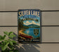 A vintage-style metal sign for Silver Lake State Park in New Hampshire, featuring a scenic image of a lake, mountains, and a canoe.