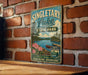 A vintage-style sign for Singletary Lake State Park, featuring a scenic landscape with a lake, mountains, and a boat.