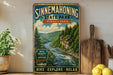A vintage-style sign for Sinneemahoning State Park in Pennsylvania, featuring a scenic image of a river surrounded by pine trees and mountains.