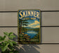 A vintage-style sign for Skinner State Park in Hadley, Massachusetts, featuring a scenic landscape with a lake and mountains.