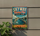 A vintage-style sign for Skyway Fishing Pier State Park in Florida, featuring an illustration of a fish jumping out of the water and a bird perched on a pier.