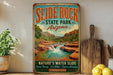 A vintage-style sign for Slide Rock State Park in Arizona, featuring a scenic image of a waterfall and rock formations.