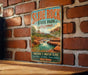 A vintage-style metal sign for Slide Rock State Park in Arizona, featuring a scenic image of a waterfall and desert landscape.