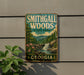 A vintage-style metal sign for Smithgall Woods State Park in Georgia, featuring a scenic landscape with a waterfall and mountains.
