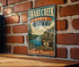 A vintage-style sign for Snake Creek State Recreation Area in South Dakota, featuring a scenic landscape with a river and mountains.