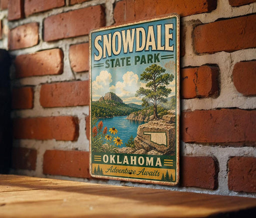 A vintage-style sign for Snowdale State Park in Oklahoma, featuring a scenic landscape with mountains, a lake, and a tree.