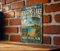 A vintage metal sign for South Higgins Lake State Park in Michigan, featuring a scenic beach and lake landscape.