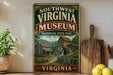 a vintage-style sign for the Southwest Virginia Museum, which is a historical state park located in Virginia. The sign displays a picture of a log cabin and a watermill, along with the text "Southwest Virginia Museum" and "Historical State Park". The sign is placed on a shelf next to a wooden cutting board and a potted plant, creating a rustic and charming atmosphere.
