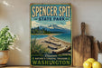 A vintage-style sign for Spencer Spit State Park in Washington, featuring a scenic image of a beach and mountains.
