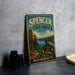 A vintage metal sign for Spencer State Forest in Massachusetts, featuring a scenic landscape with pine trees, a lake, and mountains.